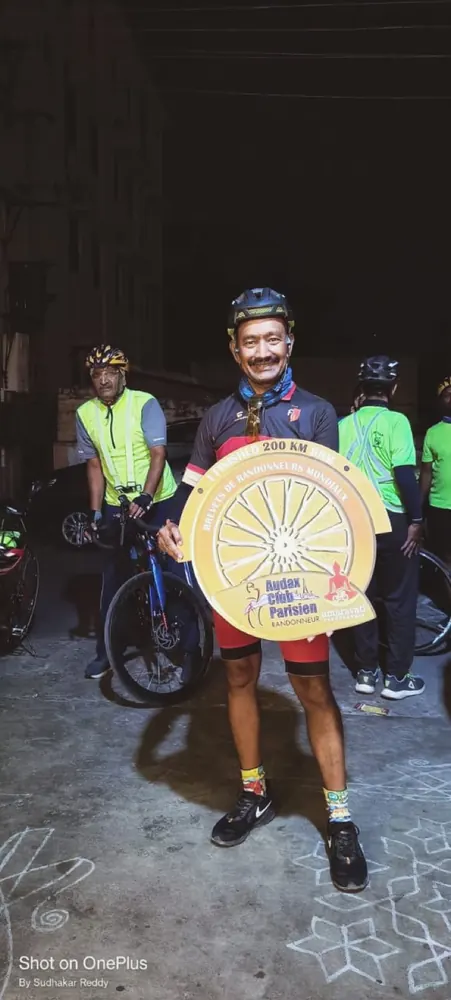 Holding the Audax Club Parisien 200 km medal at night